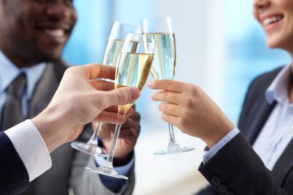 Toast for success Close-up of business partners hands cheering up with flutes of golden champagne